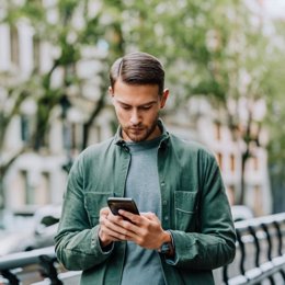 Archivo - Una persona utiliza un teléfono móvil