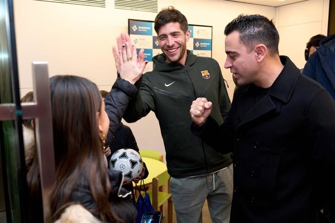 El capitán Sergi Roberto y el entrenador, Xavi Hernández, del FC Barcelona en su visita al Hospital de Barcelona el 2 de enero de 2024