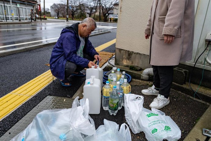 Varios residentes adquieren botellas de agua tras el terremoto en la prefectura de Ishikawa.