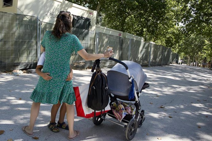 Archivo - Una persona con un carrito de bebé en el parque de El Retiro.