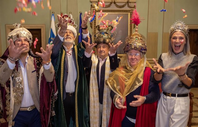 Los tres Reyes Magos, acompañados por el Heraldo Real y la Estrella de la Ilusión, reparten caramelos después de su coronación en el Ayuntamiento de Huelva.