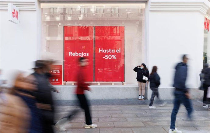 Archivo - Varias personas caminan frente a una tienda de H&M, a 3 de enero de 2023, en Madrid (España). Las marcas de ropa Mango y H&M se han adelantado este año y han colgado los carteles de rebajas antes que otras marcas tanto en sus tiendas online co