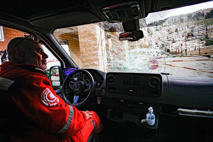 Archivo - March 29, 2023, Nablus, West Bank, Palestine: A Palestinian paramedic inspects a destroyed Red Crescent ambulance after Jewish settlers threw stones at it while it was on mission, in the Palestinian town of Hawara, south of Nablus, in the occu
