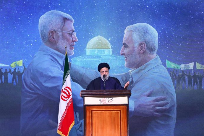 El presidente de Irán, Ebrahim Raisi, durante una ceremonia de conmemoración del aniversario de la muerte de Qasem Soleimani (en la pantalla)