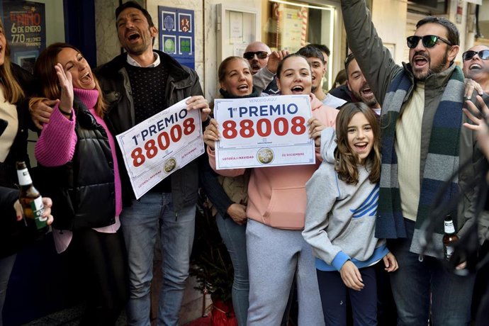 Agraciados de una administración celebran que han vendido parte del número 88008 correspondiente al Primer Premio del Sorteo Extraordinario de la Lotería de Navidad.