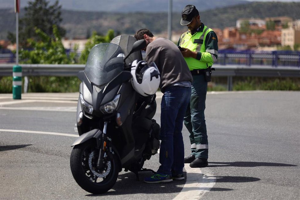 Archivo - Un agente de la Guardia Civil para a una moto en un control de tráfico 