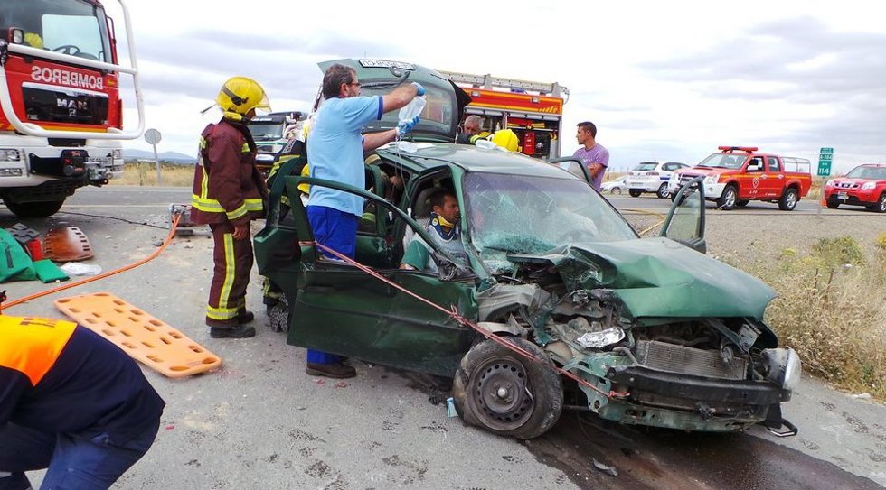Archivo - Bomberos y sanitarios atienden a un herido en accidente tráfico siniestro 