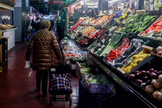 Una mujer realiza sus últimas compras antes de la cena de Nochebuena, en el Mercado de la Cebada, a 24 de diciembre de 2023, en Madrid (España). 