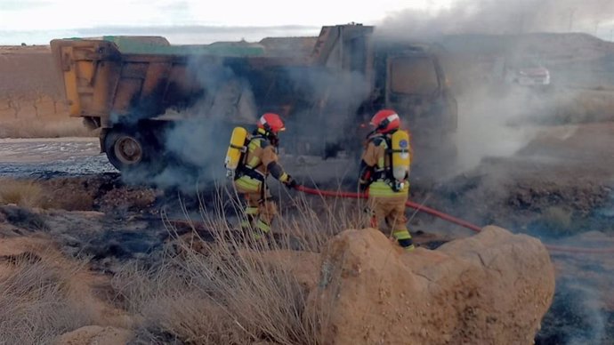 Bomberos de la Diputación Provincial de Teruel (DPT) extinguen el incendio en el camión de grava.