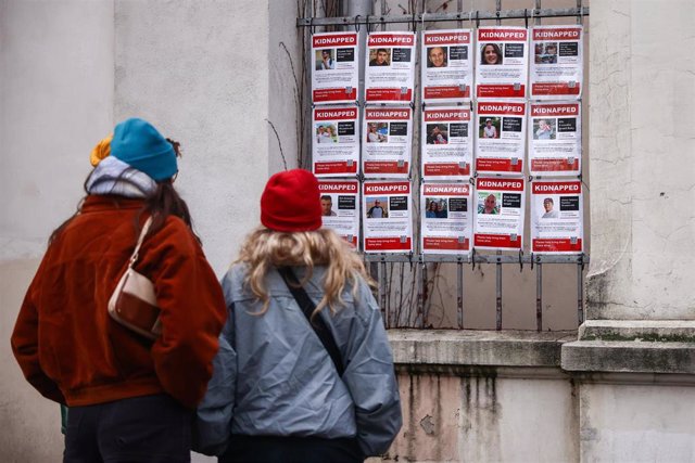 January 1, 2024, Kraków, Poland: People look at images of Israeli hostages kidnapped by Hamas hanging on a gate of  Jewish Community Centre in Krakow, Poland on January 1st, 2024. Around 240 people were taken captive by Hamas during the terror attack on I