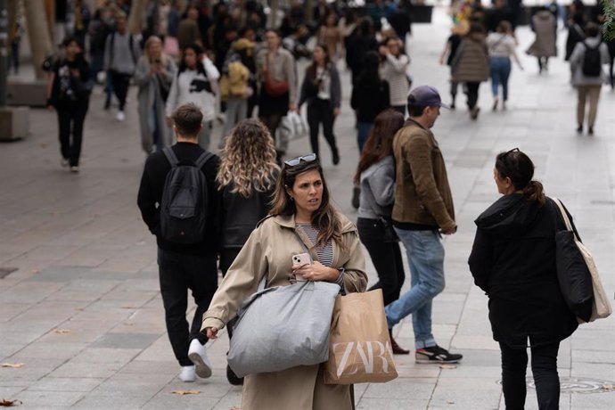 Archivo - Una mujer sujeta una bolsa con compras durante la campaña de Navidad.