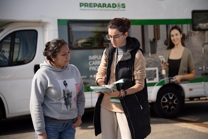 Una alumna del programa 'Preparadas' recibe información junto a la autocaravana que recorre los municipios de Andalucía.