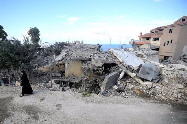 Una mujer pasa frente a edificios destruidos por un bombardeo del Ejército de Israel contra Naqura, en el sur de Líbano