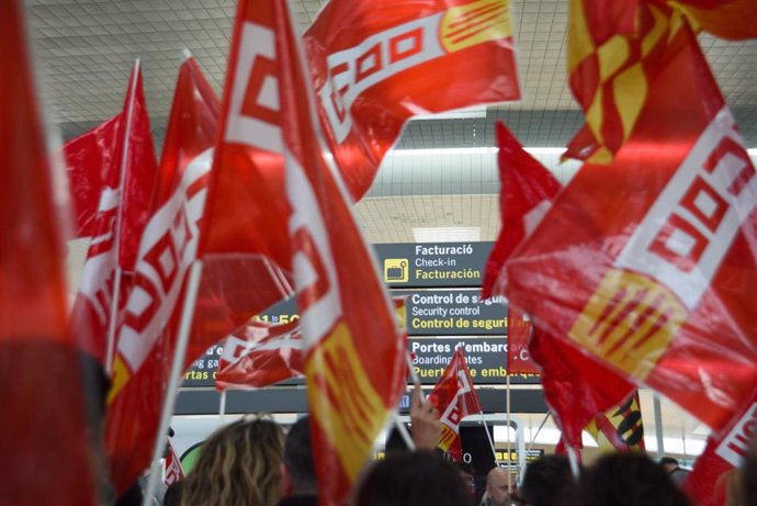 Varias personas protestan durante una concentración de CC.OO. y UGT, en el aeropuerto de Barcelona.