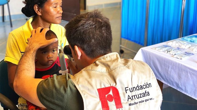 Un miembro de Fundación Arruzafa junto a un niño en una de las expediciones internacionales.