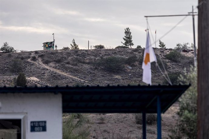 Archivo - Bandera de Chipre con un puesto de control turco en la distancia 