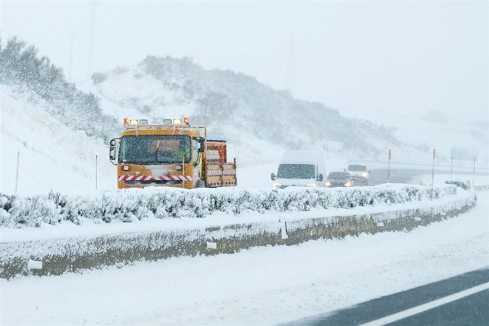 Archivo - Una máquina quitanieves aparta la nieve de la carretera, en Cantabria