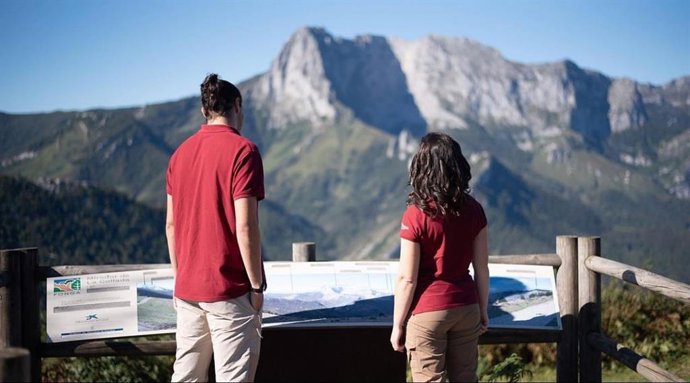 Dos personas observan las montañas en Picos de Europa.