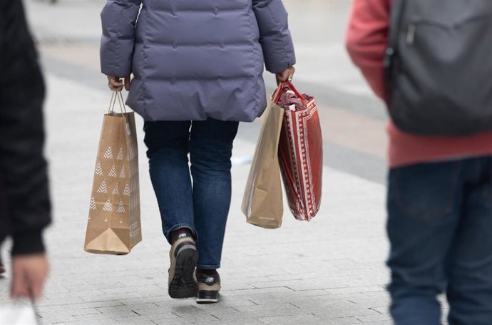 Archivo - Una persona sujeta varias bolsas con compras. Recurso. Archivo. 