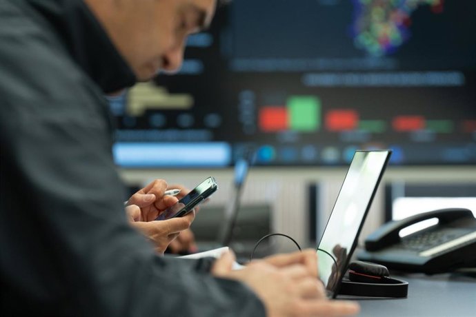 Archivo - Un trabajador de un equipo de Protecció Civil durante una prueba de envío masivo de mensajes a teléfonos móviles inteligentes para alertar de emergencias