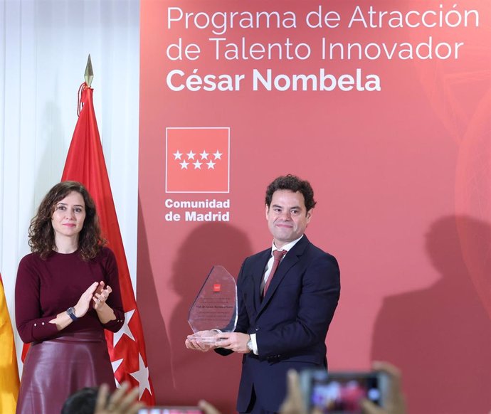 Archivo - La presidenta de la Comunidad de Madrid, Isabel Díaz Ayuso, entrega un reconocimiento al hijo del investigador César Nombela, durante la presentación de las ayudas para la atracción del talento investigador de la Comunidad de Madrid.