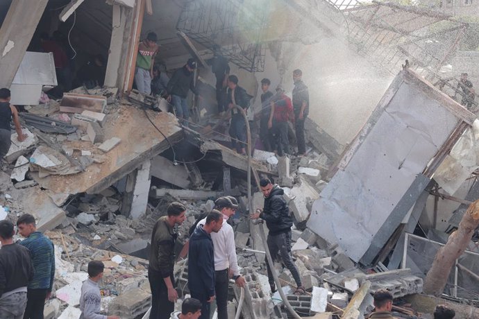 December 14, 2023, Rafah, Gaza Strip, Palestinian Territory: Rescuers and civilians look for survivors amid the rubble of destroyed buildings following Israeli bombardment in Rafah, in the southern Gaza Strip on December 14, 2023, Thousands of Palestinian