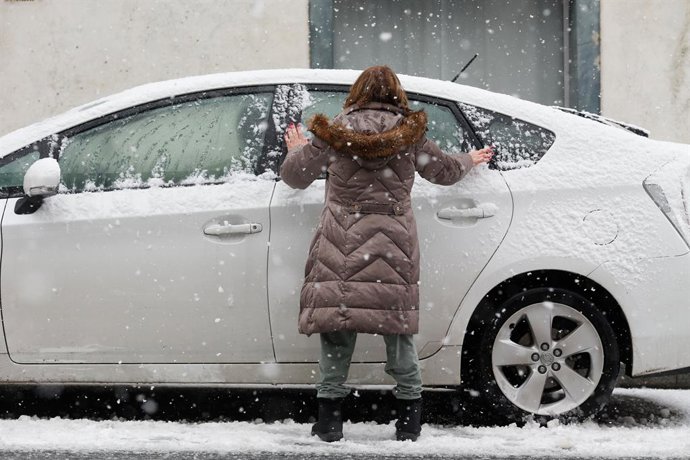 Una mujer limpia su coche de la nieve en Pedrafita do Cebreiro, a 5 de enero de 2024, en Pedrafita do Cebreiro, Lugo, Galicia (España). 