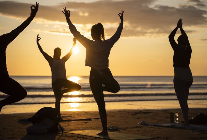 Archivo - 21 June 2023, United Kingdom, Scarborough: Members of the Happy Seal Yoga class practice on Cayton Bay in Scarborough as the sun rises to celebrate the Summer Solstice. Photo: Danny Lawson/PA Wire/dpa