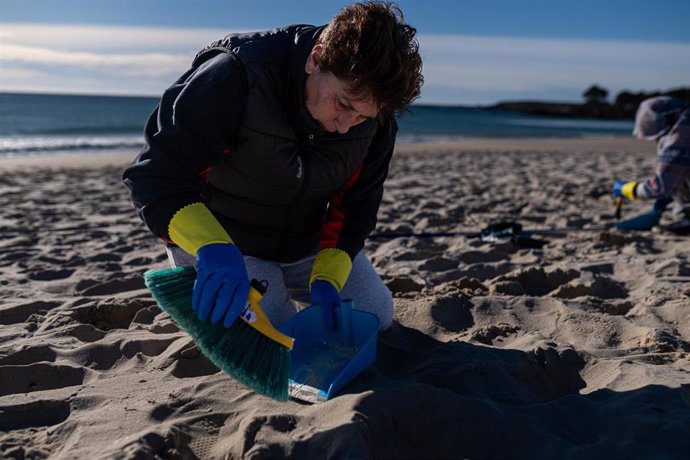 Voluntarios hacen una recogida de pellets de la arena, Galicia, a 7 de enero de 2024, en A Coruña, Galicia (España). Grandes cantidades de pellets de plásticos llevan apareciendo, desde el 13 de diciembre en las Rías Baixas y en la ría de Muros de Noia 