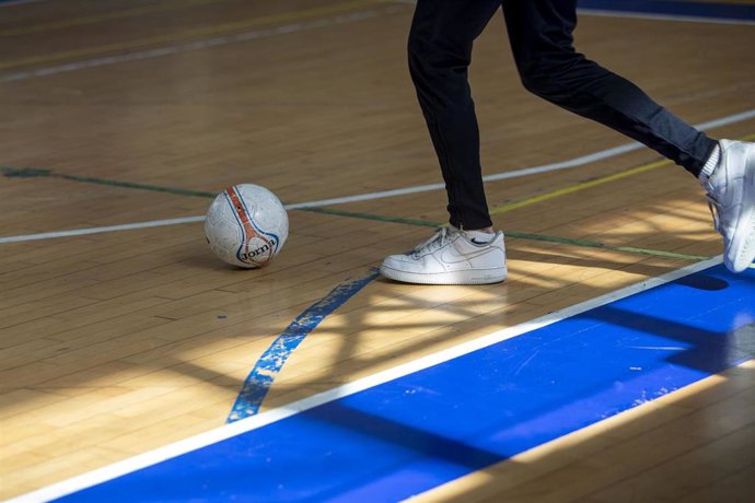 Archivo - Un niño juega al fútbol.