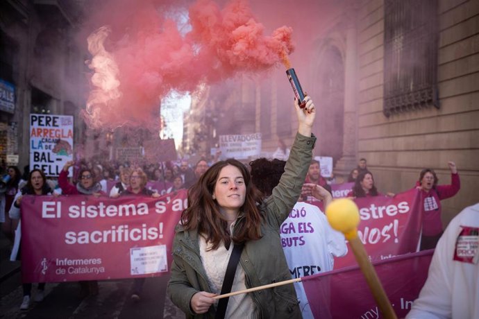 Una persona protesta con bombas de humo durante una concentración del sindicato Infermeres de Catalunya, en la plaza Sant Jaume, a 8 de enero de 2024, en Barcelona, Catalunya (España). 
