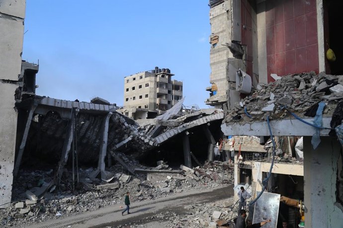 GAZA, Jan. 8, 2024  -- A man walks past destroyed buildings in the northern Gaza Strip town of Beit Lahia, on Jan. 8, 2024. The Palestinian death toll from the ongoing Israeli attacks on the Gaza Strip exceeded 23,000, the Gaza-based Health Ministry sai