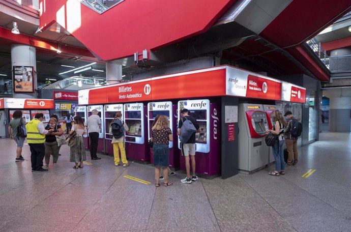 Archivo - Varias personas en las taquillas de venta automática de billetes en la estación de tren de Atocha