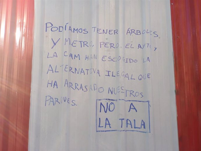 Mensajes de protesta por la tala de árboles en la valla de las obras de ampliación de la L11 en el parque de Arganzuela