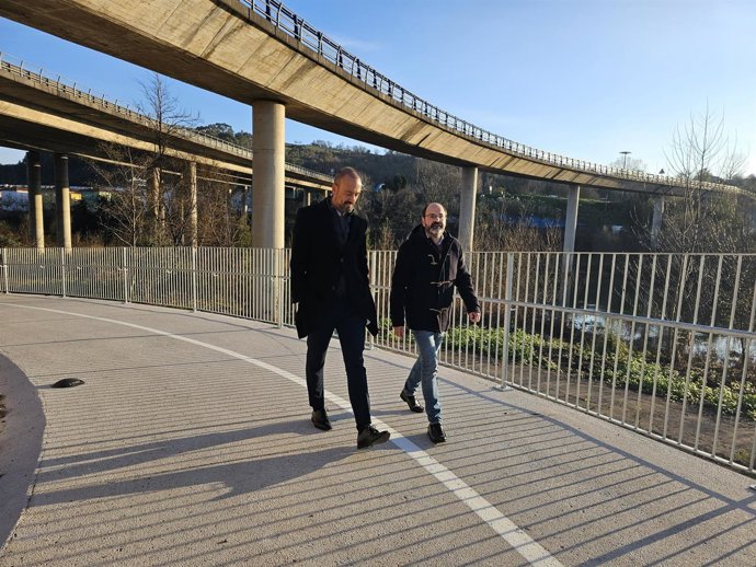 El alcalde, Javier López Estrada, y el concejal de Obras, José Luis Urraca, en la nueva rampa que une la pasarela sobre el Saja-Besaya con el parque de Las Tablas