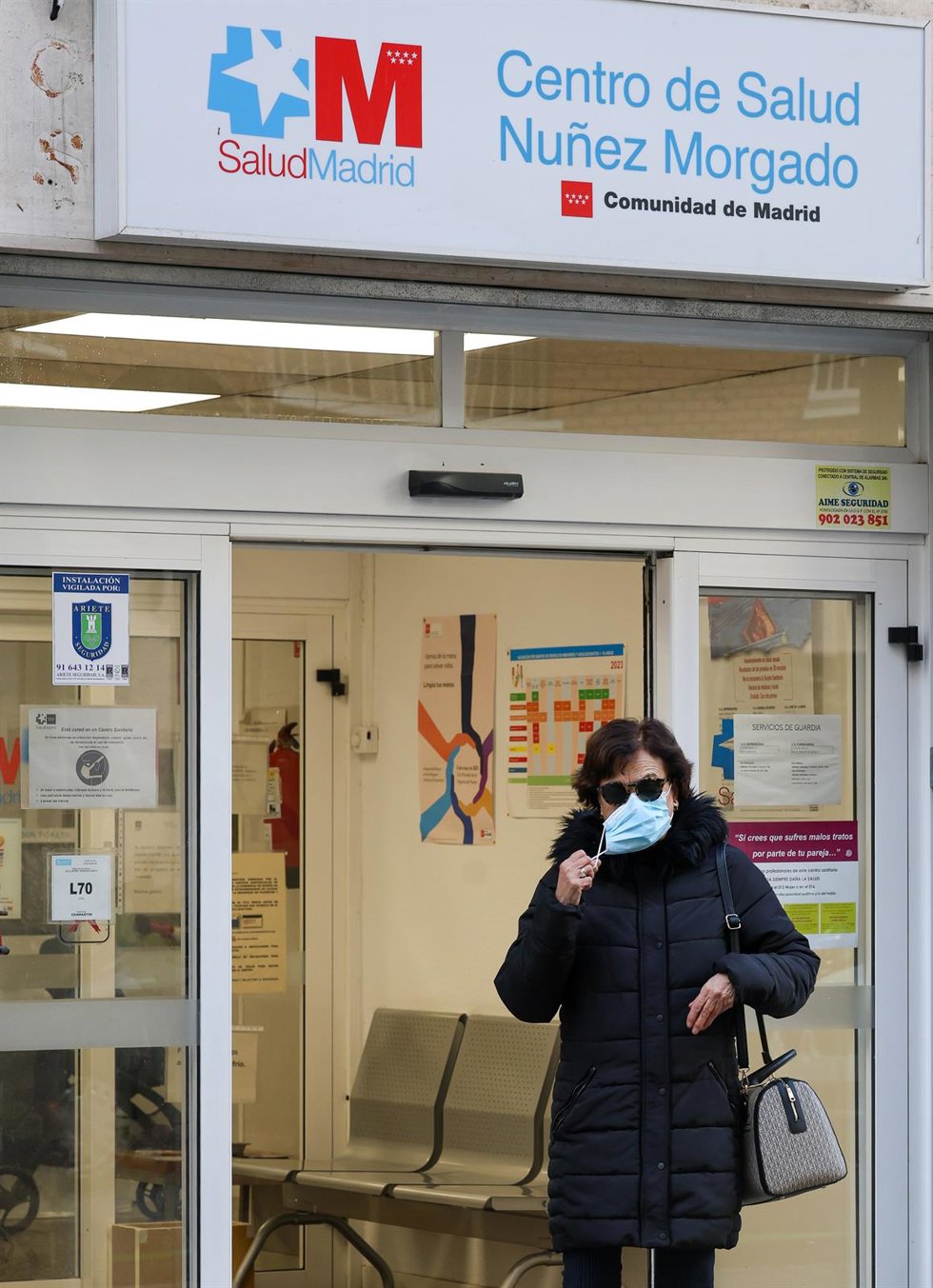 Una mujer con una mascarilla en la cara a su salida de un centro de salud