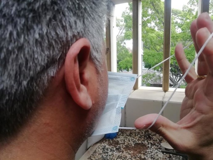 Un hombre se coloca una mascarilla