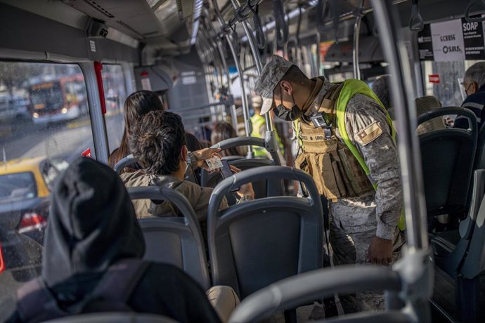 Archivo - Gente en un bus en Chile