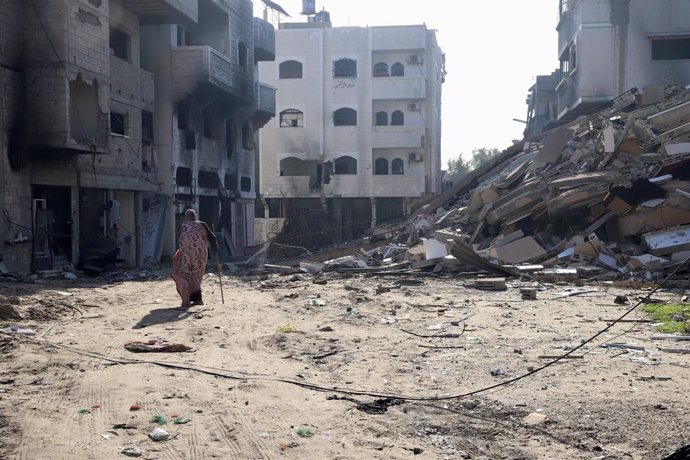 GAZA, Jan. 9, 2024  -- A man walks past damaged buildings in Jabalia refugee camp in the northern Gaza Strip, on Jan. 9, 2024. Palestinian death toll from Israeli attacks on the Gaza Strip has risen to 23,210 since the outbreak of the Israel-Hamas conflic