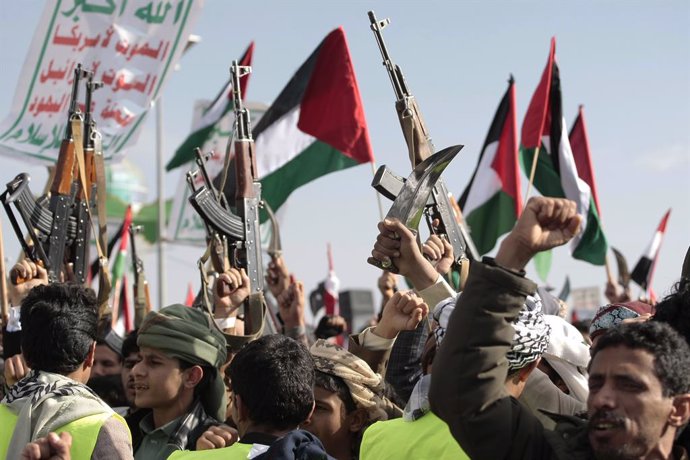 January 5, 2024, SANAA, Sanaa, Yemen: January 05, 2024, Sanaa, Yemen: A people hold up guns, wave a Palestinian flag and chants slogans during demonstrate to commemorate ten Houthi fighters killed by the U.S. Navy in the Red Sea, amid the ongoing conflict