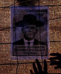 Imagen de un represaliado cordobés colocada en las vallas que rodean los trabajos de exhumación de fosas en Córdoba.