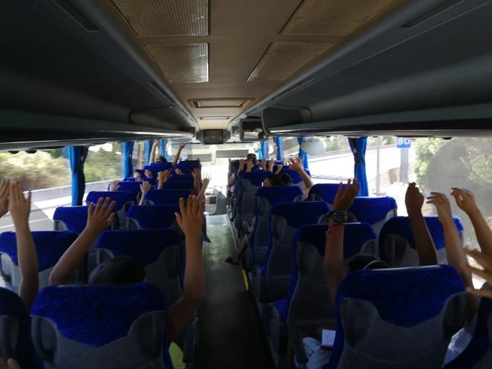 Archivo - Varios escolares viajan en un bus.