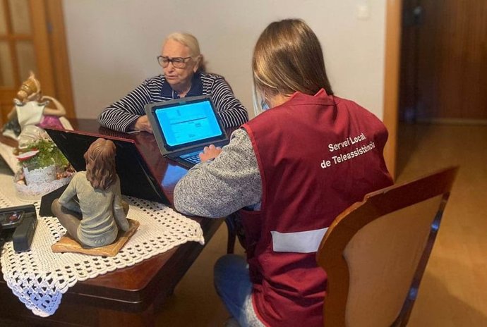 Una trabajadora del Servicio Local de Teleasistencia atiende a una persona en su domicilio.