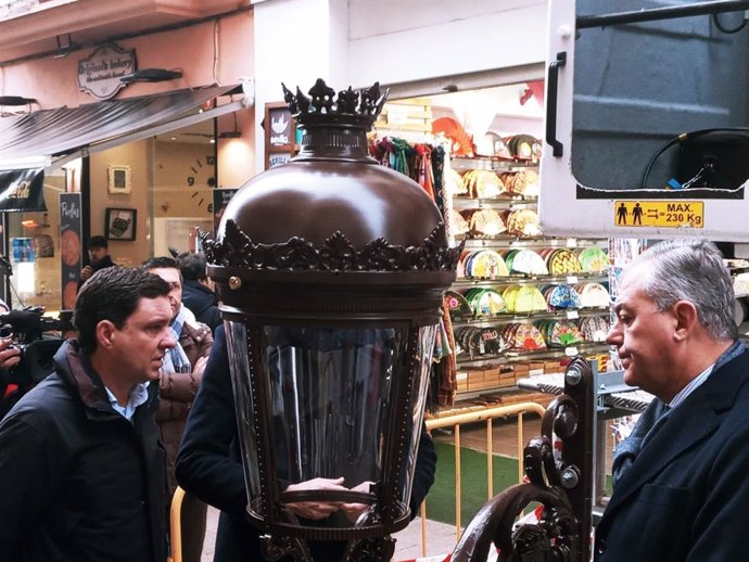 Juan de la Rosa (i) y José Luis Sanz (d) observan con detalle la primera de las farolas fernandinas que se instalará en la calle Sierpes.