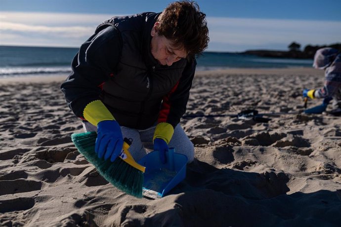 Voluntarios hacen una recogida de pellets de la arena en Galicia.