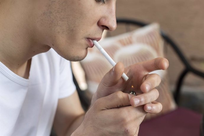 Archivo - Joven adolescente encendiendo un cigarrillo.