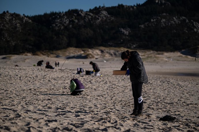Voluntarios hacen una recogida de pellets de la arena, Galicia, a 7 de enero de 2024