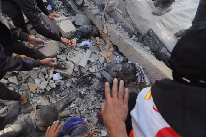 January 10, 2024, Dair El-Balah, Gaza Strip, Palestinian Territory: Residents and civil defense teams carry out a search and rescue operation around the rubble of the building demolished after Israeli attacks in Deir al-Balah, Gaza on January 10, 2024,I