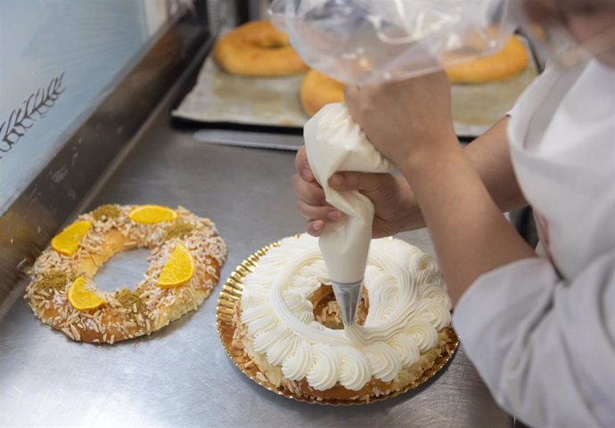 Una pastelera decora un rosco de Reyes con nata en estas pasadas Navidades, como imagen de recurso.