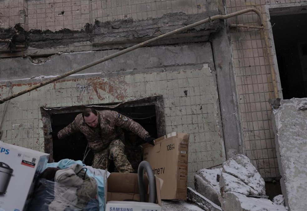 January 3, 2024: A soldier helps civilians at the destruction of a residential building after a massive missile attack that struck Kyiv, Ukraine on January 2, 2024.